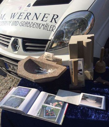 Verschiedene Produkte aus Naturstein vor Wagen von Steinmetz M. Werner