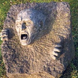 Steinskulptur mit schreiendem Gesicht